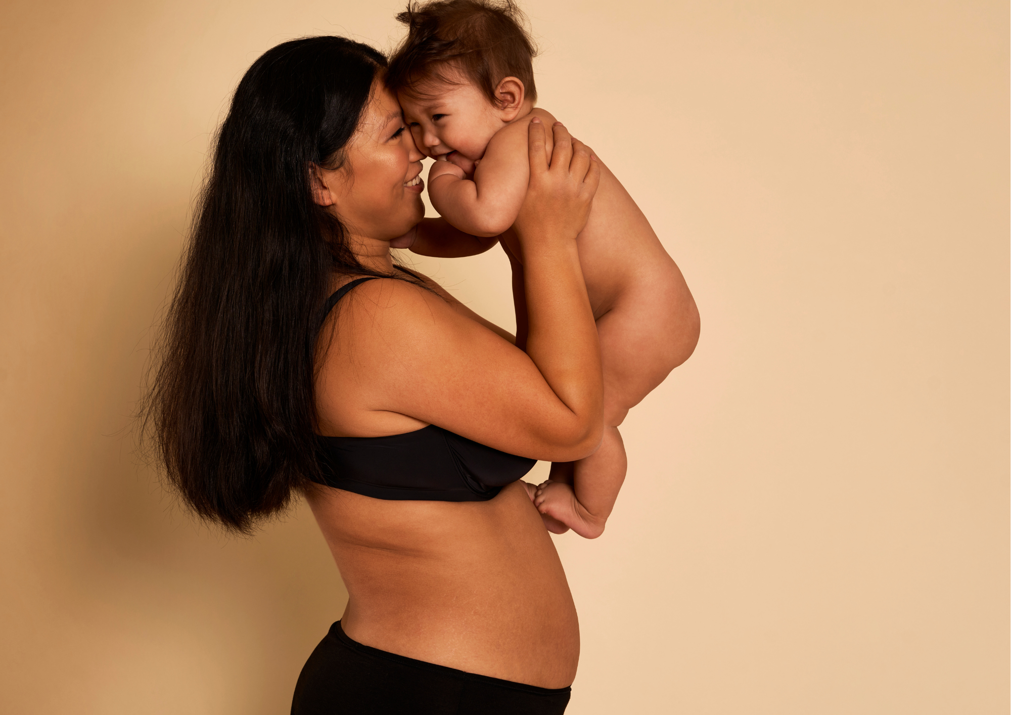 Mère heureuse avec son enfant dans les bras. Accompagnement des mères et future parent.